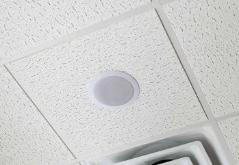 Ceiling tile mounted overhead paging speaker in commercial office
